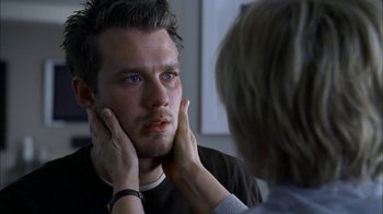 Movie still from “The Butterfly Effect 2” (2006), directed by John R. Leonetti – A man looking at a woman's face in the mirror; Close Up shot, Over the shoulder angle