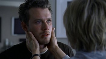 Movie still from “The Butterfly Effect 2” (2006), directed by John R. Leonetti – A person touching a mans face in front of a mirror; Close Up shot, Over the shoulder angle