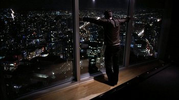 Movie still from “The Butterfly Effect 2” (2006), directed by John R. Leonetti – A man standing in front of a window at night; Wide shot, High angle