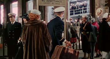 Movie still from “The Caine Mutiny” (1954), directed by Edward Dmytryk – A group of people walking down a sidewalk; Wide shot, Over the shoulder angle