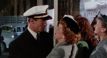 Movie still from “The Caine Mutiny” (1954), directed by Edward Dmytryk – A man and a woman wearing hats and a uniform; Medium shot, Over the shoulder angle