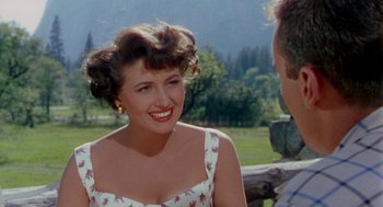 Movie still from “The Caine Mutiny” (1954), directed by Edward Dmytryk – A woman in a floral dress smiling at a man; Close Up shot, Over the shoulder angle