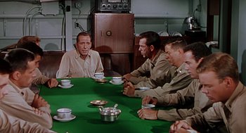 Movie still from “The Caine Mutiny” (1954), directed by Edward Dmytryk – A group of men sitting around a table with plates of food on it; Medium shot, High angle
