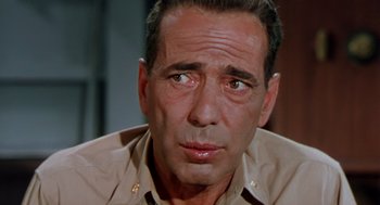 Movie still from “The Caine Mutiny” (1954), directed by Edward Dmytryk – An older man in a tan shirt looking to his left; Close Up shot, Over the shoulder angle