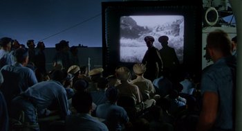 Movie still from “The Caine Mutiny” (1954), directed by Edward Dmytryk – A group of people watching a movie on a projector screen; Extreme Wide shot, High angle