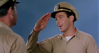 Movie still from “The Caine Mutiny” (1954), directed by Edward Dmytryk – A man saluting with a hat on his head; Medium shot, Low angle