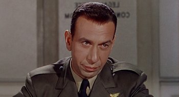 Movie still from “The Caine Mutiny” (1954), directed by Edward Dmytryk – A man in a military uniform is looking at the camera; Close Up shot, Low angle