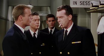 Movie still from “The Caine Mutiny” (1954), directed by Edward Dmytryk – A group of men standing next to each other in uniforms; Medium shot, Over the shoulder angle