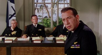 Movie still from “The Caine Mutiny” (1954), directed by Edward Dmytryk – Two men in military uniforms sitting at a table; Medium shot, Low angle