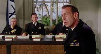 Movie still from “The Caine Mutiny” (1954), directed by Edward Dmytryk – Three men in military uniforms sitting at a table in front of a window; Medium shot, Over the shoulder angle