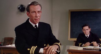 Movie still from “The Caine Mutiny” (1954), directed by Edward Dmytryk – A person wearing a suit and tie; Medium shot, Over the shoulder angle