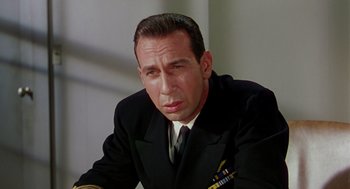 Movie still from “The Caine Mutiny” (1954), directed by Edward Dmytryk – A person wearing a suit and tie; Close Up shot, High angle
