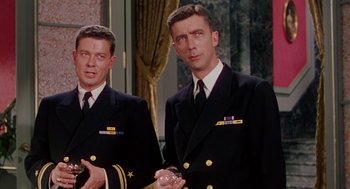 Movie still from “The Caine Mutiny” (1954), directed by Edward Dmytryk – A couple of men standing next to each other in suits; Medium shot, Low angle