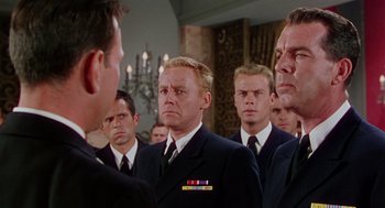Movie still from “The Caine Mutiny” (1954), directed by Edward Dmytryk – A group of men wearing suits and ties in front of a chandelier; Medium shot, Low angle