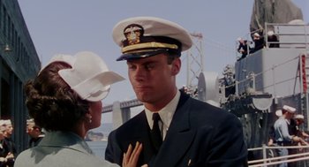 Movie still from “The Caine Mutiny” (1954), directed by Edward Dmytryk – A man in a uniform and a woman in a white hat; Medium shot, Low angle