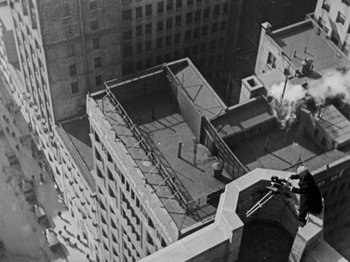 Movie still from “The Cameraman” (1928), directed by Buster Keaton – An aerial view of a building with smoke coming out of it; Extreme Wide shot, Overhead angle
