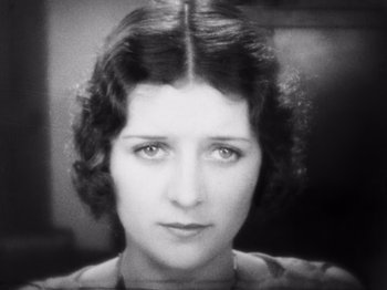 Movie still from “The Cameraman” (1928), directed by Buster Keaton – An old photo of an older woman with short dark hair; Close Up shot, High angle