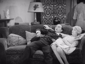 Movie still from “The Cameraman” (1928), directed by Buster Keaton – A man and a woman sitting on top of a couch; Medium shot, High angle
