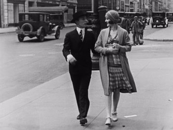 Movie still from “The Cameraman” (1928), directed by Buster Keaton – A man and a woman walking down a street; Medium shot, Low angle