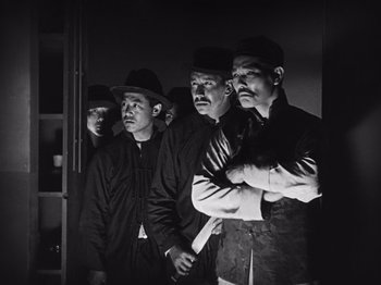 Movie still from “The Cameraman” (1928), directed by Buster Keaton – A black and white photo of a group of men standing next to each other; Medium shot, Low angle
