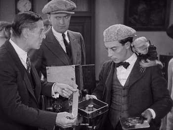 Movie still from “The Cameraman” (1928), directed by Buster Keaton – A group of men standing next to each other; Medium shot, High angle