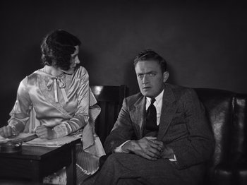 Movie still from “The Cameraman” (1928), directed by Buster Keaton – A man and a woman sitting at a table; Medium shot, High angle