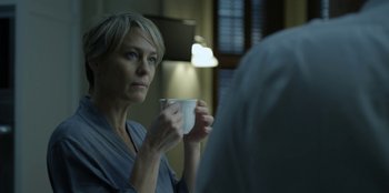 Movie still from “House of Cards” (2013), created by Beau Willimon – A woman is holding a coffee cup in her hands; Close Up shot, Over the shoulder angle