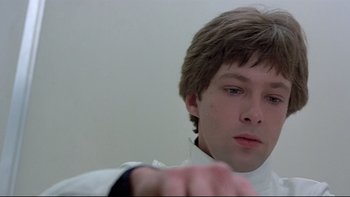 Movie still from “The Cassandra Crossing” (1976), directed by George P. Cosmatos – A young man in a white shirt is looking at the camera; Close Up shot, Low angle