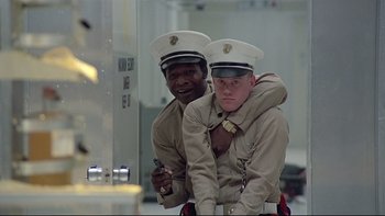 Movie still from “The Cassandra Crossing” (1976), directed by George P. Cosmatos – A couple of people that are in a room; Medium shot, Low angle