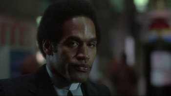 Movie still from “The Cassandra Crossing” (1976), directed by George P. Cosmatos – A person wearing a suit and tie; Close Up shot, Low angle