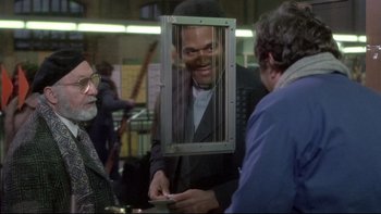 Movie still from “The Cassandra Crossing” (1976), directed by George P. Cosmatos – A man holding a cell phone up to his face; Medium shot, Over the shoulder angle