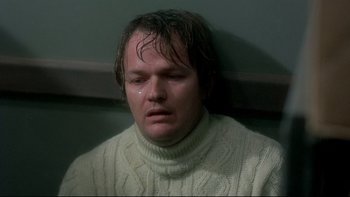 Movie still from “The Cassandra Crossing” (1976), directed by George P. Cosmatos – A man in a white sweater is crying; Close Up shot, High angle
