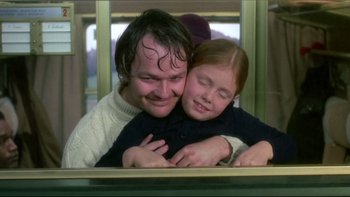 Movie still from “The Cassandra Crossing” (1976), directed by George P. Cosmatos – A man and a little girl are hugging each other; Close Up shot, Low angle