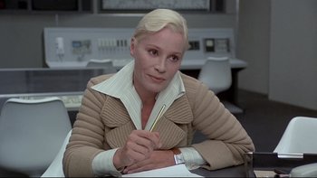 Movie still from “The Cassandra Crossing” (1976), directed by George P. Cosmatos – A woman sitting at a table writing on a piece of paper; Medium shot, Low angle