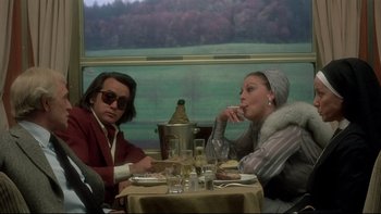 Movie still from “The Cassandra Crossing” (1976), directed by George P. Cosmatos – A man and a woman sitting at a dinner table; Medium shot, Over the shoulder angle