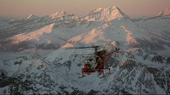 Movie still from “The Cassandra Crossing” (1976), directed by George P. Cosmatos – A helicopter flying over a snowy mountain range; Extreme Wide shot, High angle