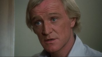 Movie still from “The Cassandra Crossing” (1976), directed by George P. Cosmatos – A man with blonde hair and blue eyes stares at the camera; Close Up shot, High angle
