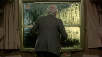 Movie still from “The Cassandra Crossing” (1976), directed by George P. Cosmatos – A man standing in front of a window looking outside; Medium shot, Over the shoulder angle