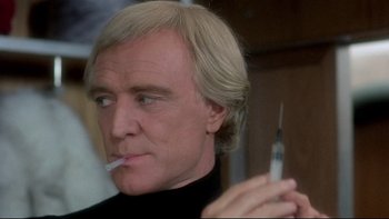 Movie still from “The Cassandra Crossing” (1976), directed by George P. Cosmatos – A person holding a syringe; Close Up shot, Low angle