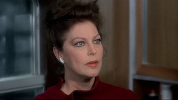 Movie still from “The Cassandra Crossing” (1976), directed by George P. Cosmatos – A person wearing a red shirt; Close Up shot, Over the shoulder angle