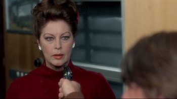 Movie still from “The Cassandra Crossing” (1976), directed by George P. Cosmatos – A woman in a red coat is holding a gun; Close Up shot, Over the shoulder angle