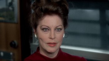 Movie still from “The Cassandra Crossing” (1976), directed by George P. Cosmatos – A person wearing a red shirt; Close Up shot, Over the shoulder angle