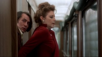 Movie still from “The Cassandra Crossing” (1976), directed by George P. Cosmatos – A man and a woman are walking in a train; Medium shot, Low angle
