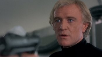 Movie still from “The Cassandra Crossing” (1976), directed by George P. Cosmatos – A person holding a gun; Close Up shot, Low angle