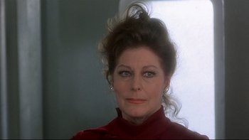 Movie still from “The Cassandra Crossing” (1976), directed by George P. Cosmatos – A person wearing a red shirt; Close Up shot, Over the shoulder angle