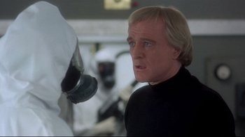 Movie still from “The Cassandra Crossing” (1976), directed by George P. Cosmatos – A man in black shirt looking at another man in white shirt; Close Up shot, Over the shoulder angle