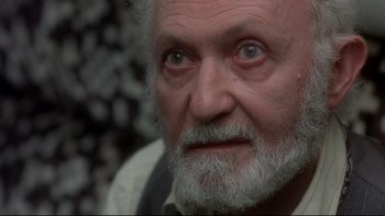 Movie still from “The Cassandra Crossing” (1976), directed by George P. Cosmatos – An old man with a beard and a white mustache; Close Up shot, Over the shoulder angle