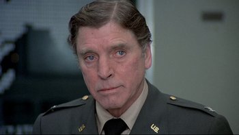 Movie still from “The Cassandra Crossing” (1976), directed by George P. Cosmatos – A person wearing a military uniform; Close Up shot, Over the shoulder angle