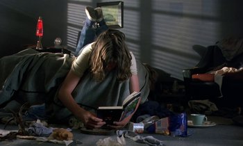 Movie still from “The Cement Garden” (1993), directed by Andrew Birkin – A woman is reading a book on the floor; Wide shot, High angle