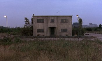 Movie still from “The Cement Garden” (1993), directed by Andrew Birkin – An abandoned building in the middle of a field at night; Extreme Wide shot, Low angle